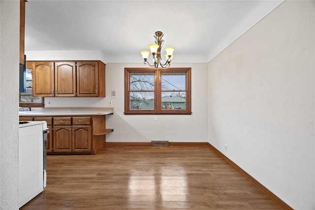 kitchen featuring electric stove, dark wood-type flooring, an inviting chandelier, and pendant lighting