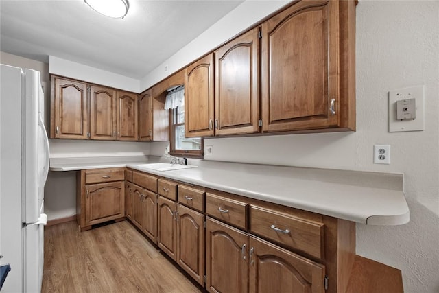 kitchen featuring white refrigerator, sink, and light hardwood / wood-style floors