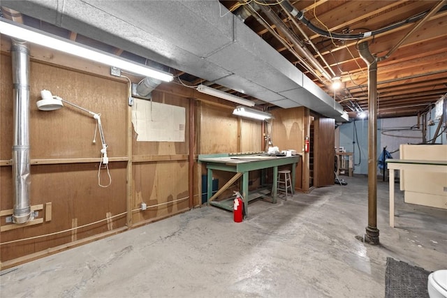 basement featuring wood walls