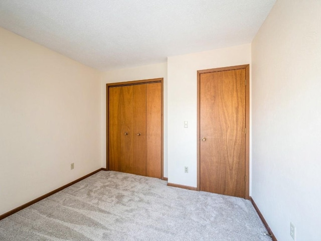 unfurnished bedroom featuring light colored carpet and a closet