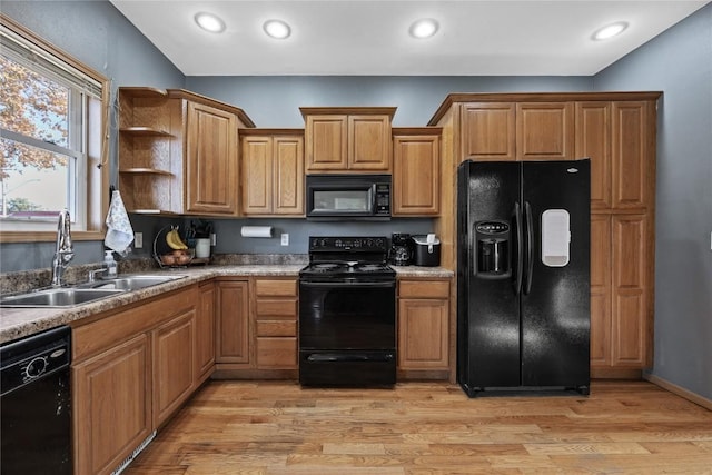 kitchen featuring sink, black appliances, and light hardwood / wood-style floors