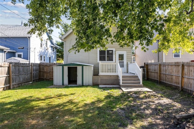 rear view of house featuring a storage shed and a yard