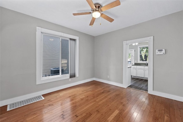 unfurnished room featuring ceiling fan, wood-type flooring, and sink