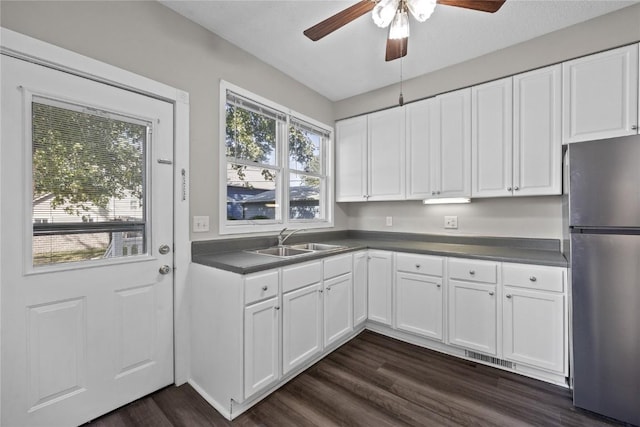 kitchen featuring sink, dark wood-type flooring, stainless steel refrigerator, ceiling fan, and white cabinets