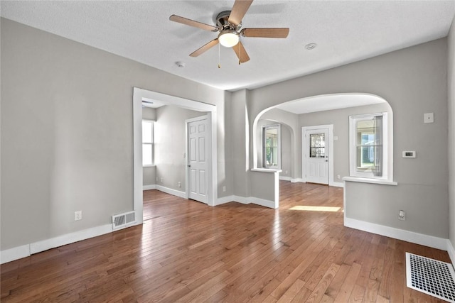 empty room with hardwood / wood-style floors, a textured ceiling, and ceiling fan