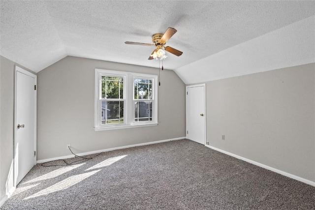 bonus room featuring lofted ceiling, ceiling fan, a textured ceiling, and carpet flooring