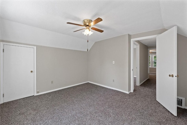 bonus room featuring ceiling fan, vaulted ceiling, a textured ceiling, and dark colored carpet