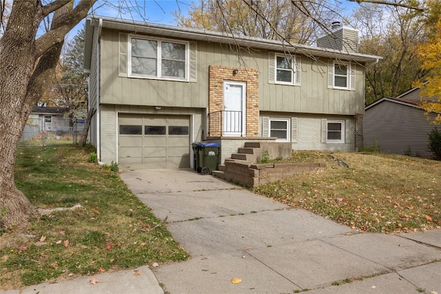 split foyer home featuring a garage and a front lawn