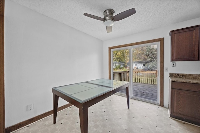 unfurnished dining area with ceiling fan and a textured ceiling