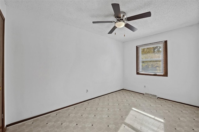 unfurnished room with ceiling fan and a textured ceiling