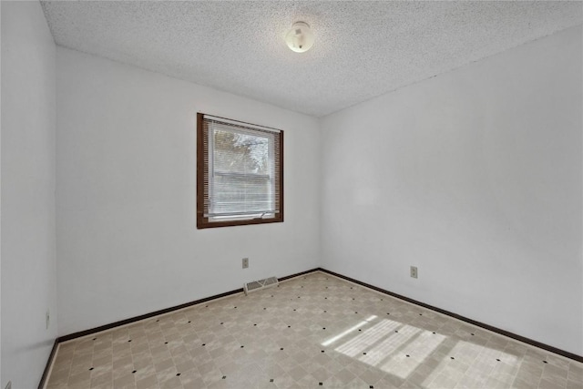 unfurnished room featuring a textured ceiling