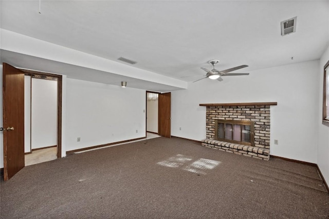 unfurnished living room with a brick fireplace, carpet floors, and ceiling fan