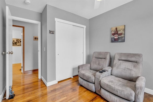 sitting room with ceiling fan and light wood-type flooring