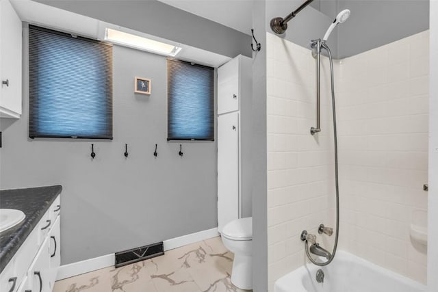 full bathroom featuring tiled shower / bath combo, vanity, and toilet