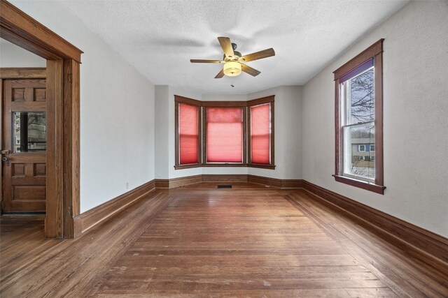 spare room with hardwood / wood-style flooring, ceiling fan, and a textured ceiling