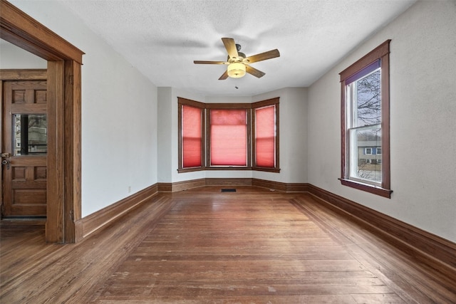 spare room featuring ceiling fan, wood-type flooring, and a textured ceiling