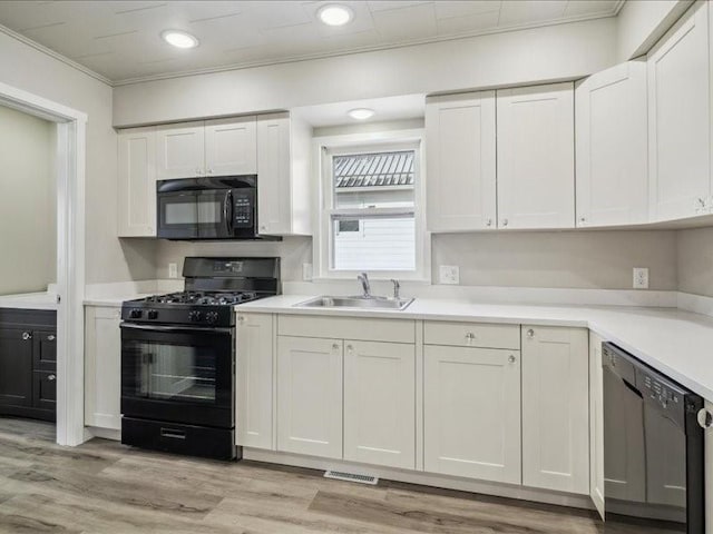 kitchen featuring sink, white cabinets, and black appliances