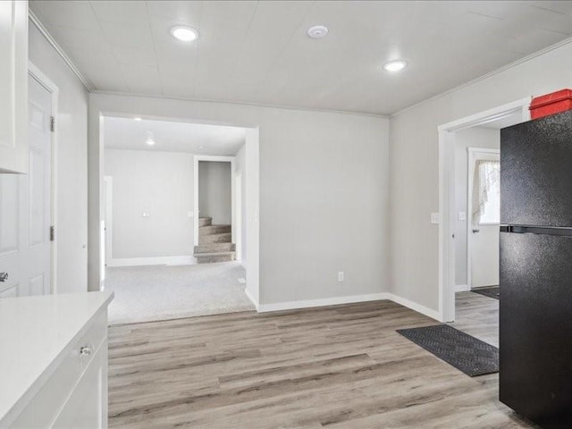 interior space featuring ornamental molding and light hardwood / wood-style floors