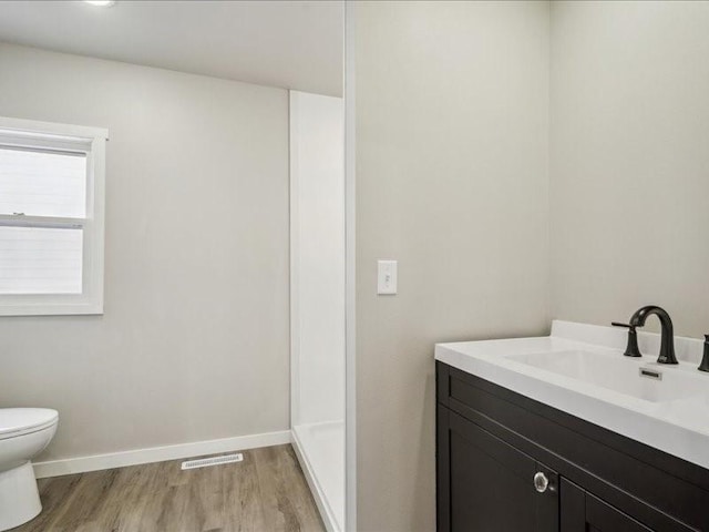 bathroom with vanity, wood-type flooring, and toilet