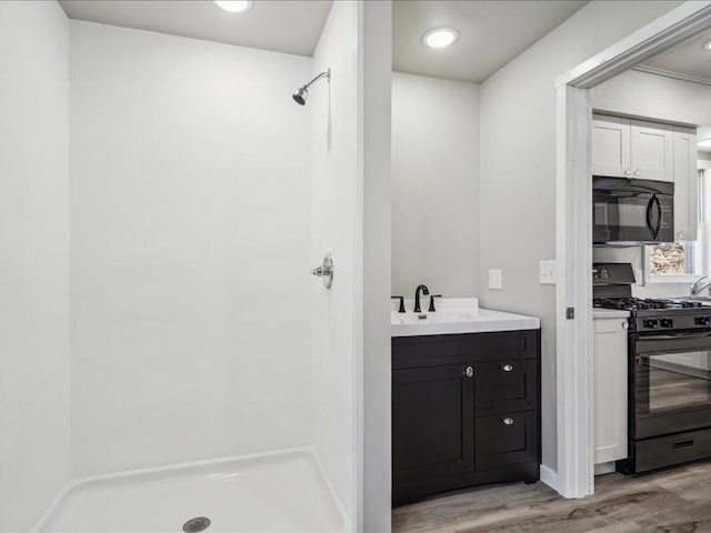 bathroom with vanity, hardwood / wood-style flooring, and walk in shower