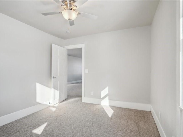 carpeted spare room with ceiling fan