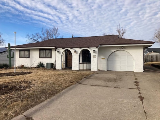 single story home featuring central AC and a garage