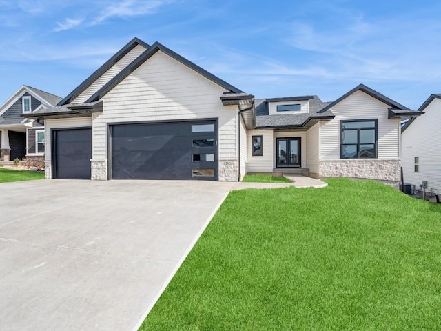 view of front facade with a garage, a front yard, and central AC unit