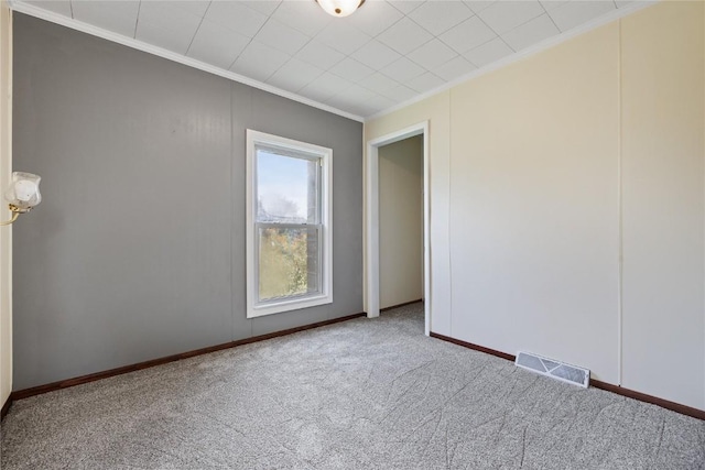 spare room featuring crown molding and carpet flooring