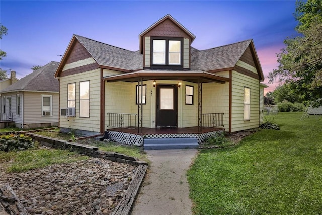 view of front facade featuring cooling unit, a yard, and a porch