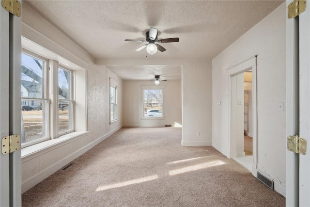 carpeted spare room with a textured ceiling