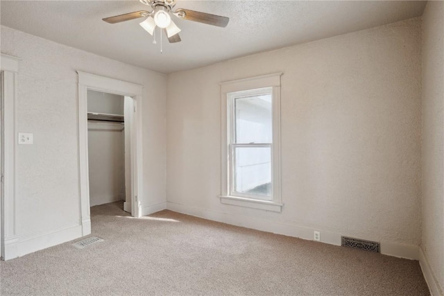 unfurnished bedroom featuring ceiling fan, light colored carpet, and a closet