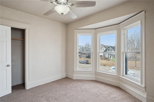 unfurnished bedroom featuring a textured ceiling, carpet floors, and ceiling fan