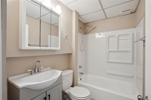 full bathroom featuring vanity, shower / tub combination, toilet, and a drop ceiling