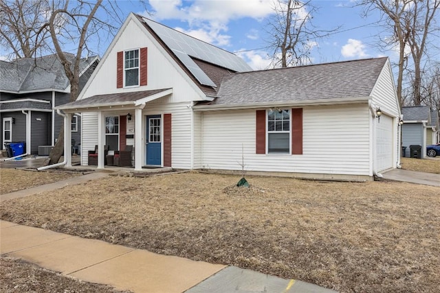 view of front of home with a garage, a front yard, and solar panels