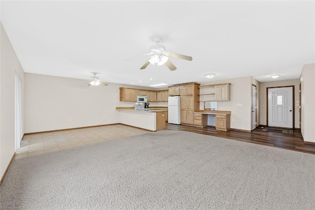 unfurnished living room with dark colored carpet and ceiling fan