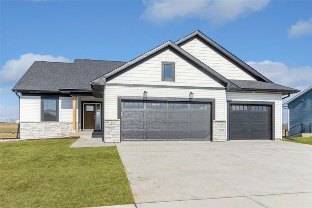 craftsman inspired home featuring a garage and a front lawn