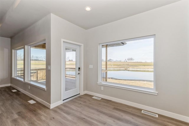 entryway with a water view and hardwood / wood-style flooring