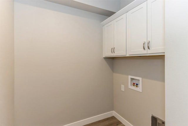 clothes washing area with dark wood-type flooring, cabinets, and hookup for a washing machine