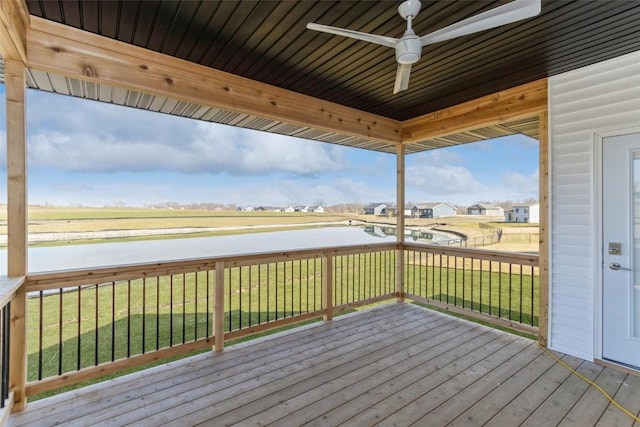 wooden terrace featuring a water view, ceiling fan, and a yard