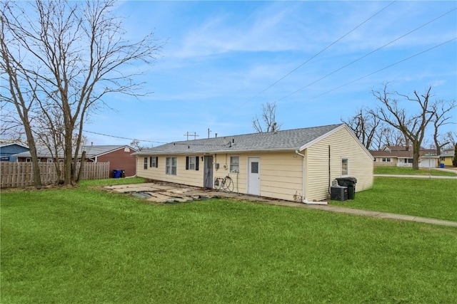 rear view of house featuring a lawn, central air condition unit, and a patio area