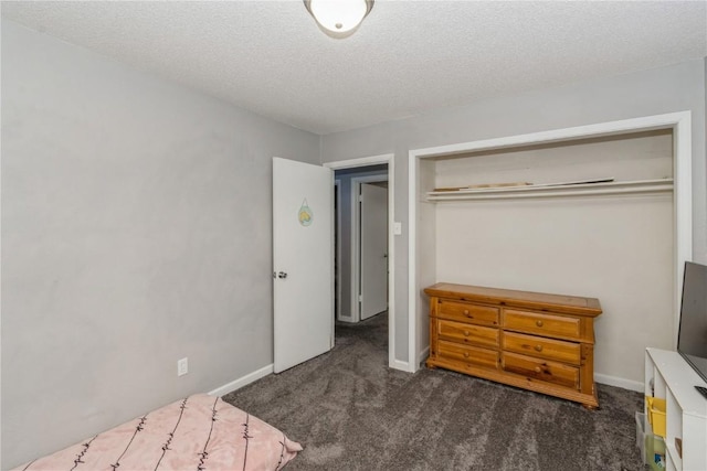 bedroom featuring dark colored carpet and a textured ceiling