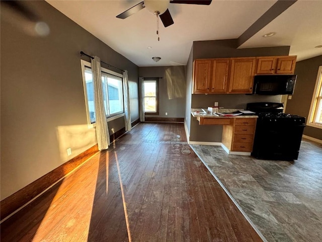 1609 11th Ave, Belle Plaine, IA 52208 - kitchen featuring ceiling fan, brown cabinets, baseboards, black appliances, and dark wood-style floors