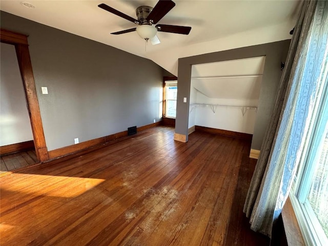 1609 11th Ave, Belle Plaine, IA 52208 - unfurnished bedroom with a closet, lofted ceiling, baseboards, hardwood / wood-style flooring, and a ceiling fan