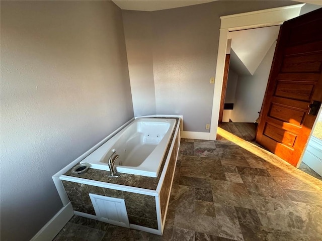 1609 11th Ave, Belle Plaine, IA 52208 - full bathroom with baseboards, stone finish floor, and a jetted tub