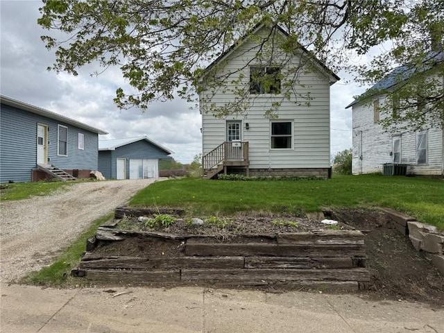 1609 11th Ave, Belle Plaine, IA 52208 - exterior space featuring a lawn, dirt driveway, an outbuilding, and central AC unit