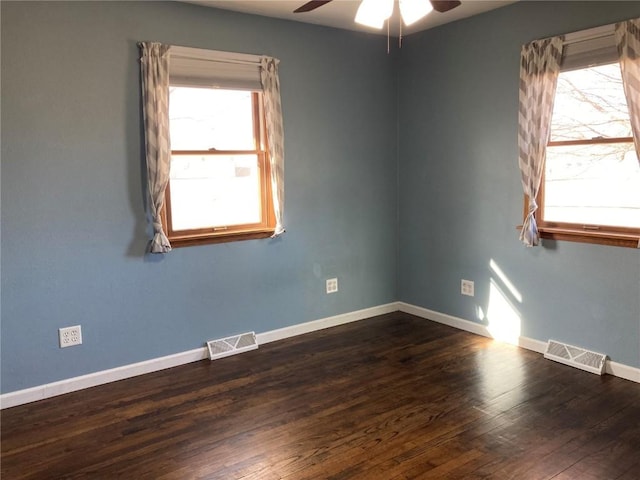 empty room featuring dark wood-type flooring and ceiling fan