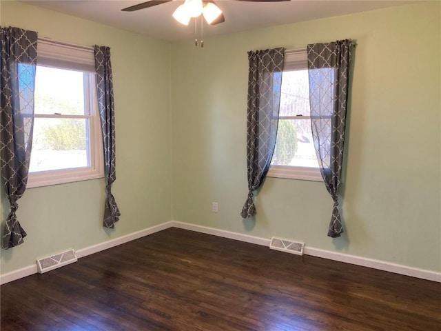 empty room with ceiling fan and dark hardwood / wood-style flooring