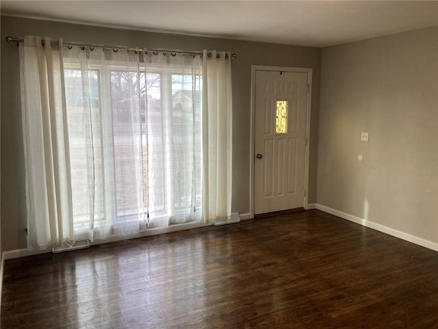 foyer entrance with a healthy amount of sunlight and dark hardwood / wood-style flooring