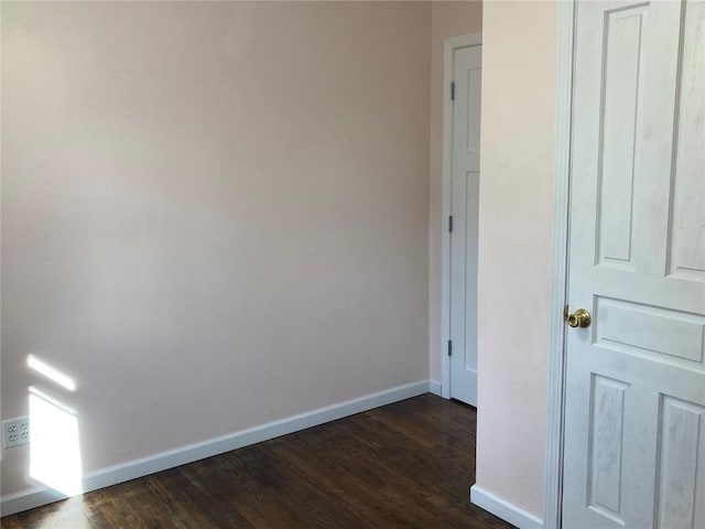 unfurnished room with dark wood-type flooring