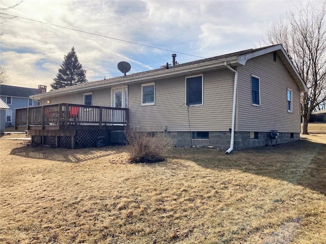 rear view of property featuring a wooden deck, a yard, and central air condition unit